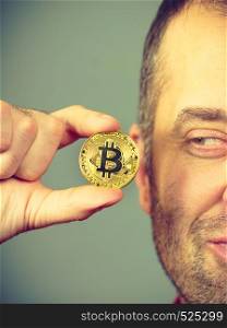 Man hand holding golden bitcoin coin sign, digital symbol of new virtual currency. Man hand holding golden bitcoin