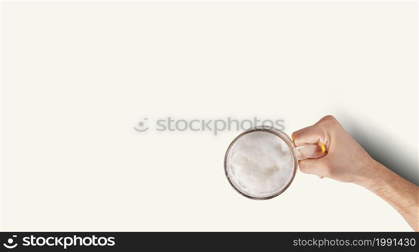 Man Hand Holding Mug Full Of Beer On White Background. Isolated top up view.