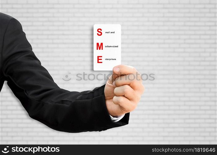 Man hand holding paper card with word SME. Concept of small and medium-sized enterprises business.