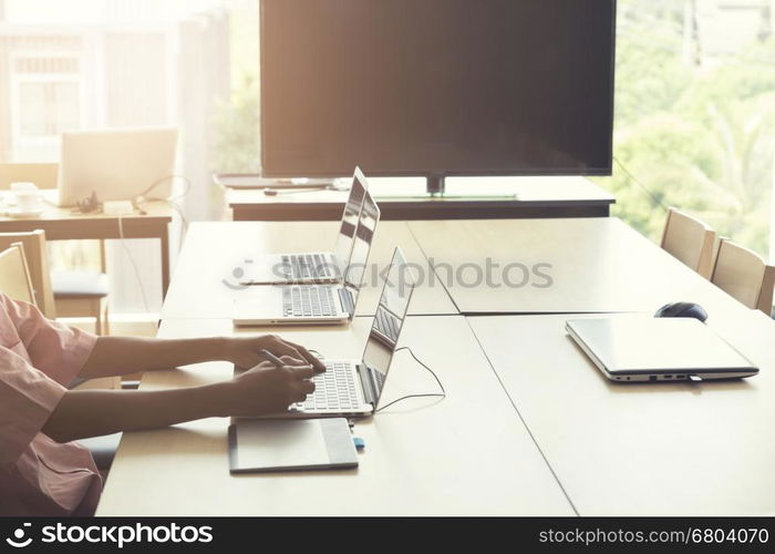 man' hand holding pen working on digital tablet and computer notebook for graphic design work, vintage tone