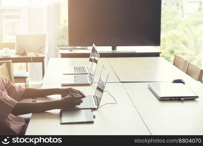 man' hand holding pen working on digital tablet and computer notebook for graphic design work, vintage tone