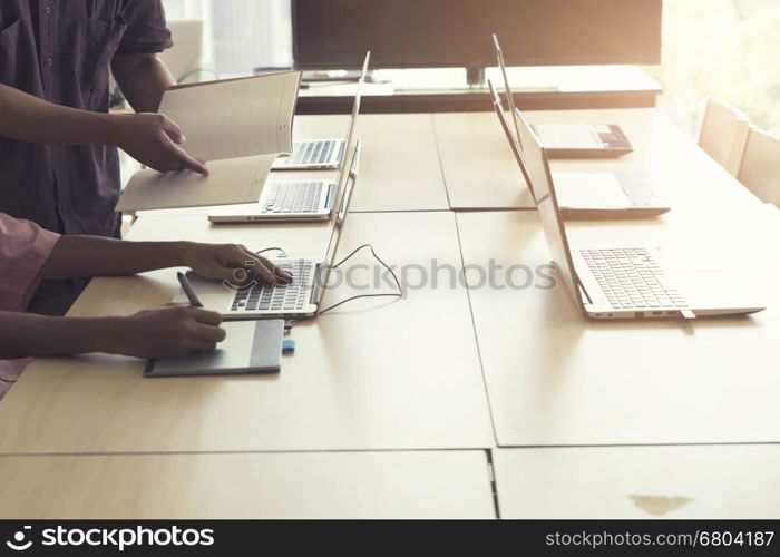 man' hand holding pen working on digital tablet and computer notebook for graphic design work, vintage tone