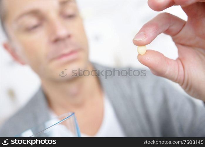 man hand holding pill close up