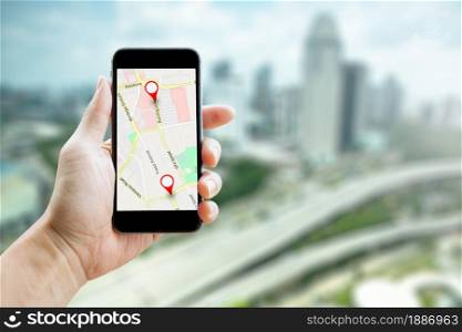 Man hand holding smartphone with GPS Map to Route Destination network connection. Location Street Map with GPS Icons Navigation and Red icon of location. Online Navigation Concept.