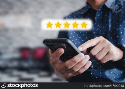 Man hand holding use mobile phone icon Stars Rating 5 star excellent rating or commenting service. Social concept.