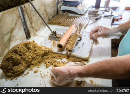 Man hand prepares traditional Lok or Tatuni dessert.Lok dessert made by mixing dried mulberries floor and walnut and then mashing for3 hours. Kemaliye,Turkey.. Traditional Lok or Tatuni dessert in Kemaliye,Turkey