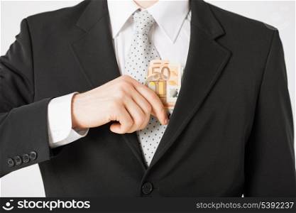 man hand putting euro cash money into suit pocket