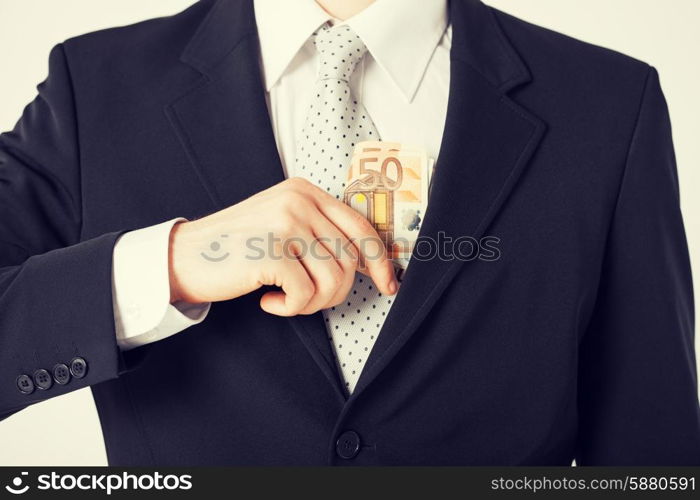 man hand putting euro cash money into suit pocket