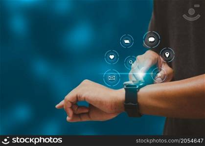 Man hand touching a smart watch virtual icon. Communication and use of modern Internet technology metaverse, Social Networking, online marketing, digital online. Concept technology.