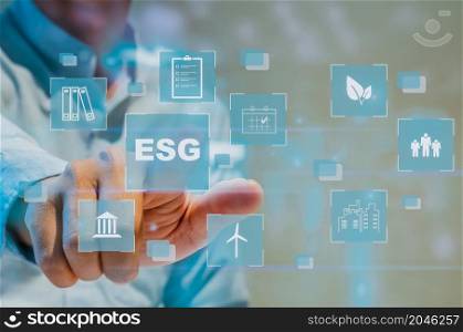 Man hand touching ESG word with icon business virtual interface screen concept.ESG Environment social governance investment business