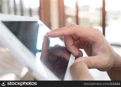 Man hand touching screen on modern digital tablet pc. Close-up image with shallow depth of field focus on finger