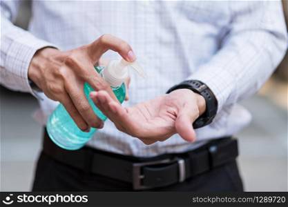 man hand using wash hand sanitizer gel dispenser, against Novel coronavirus or Corona Virus Disease (Covid-19) at public Indoor. Antiseptic, Hygiene and Healthcare concept