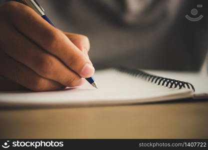 Man hand with pen writing on notebook.