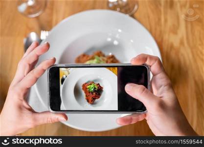 Man hand with smartphone photographing food at restaurant or cafe. High quality photo. Man hand with smartphone photographing food at restaurant or cafe