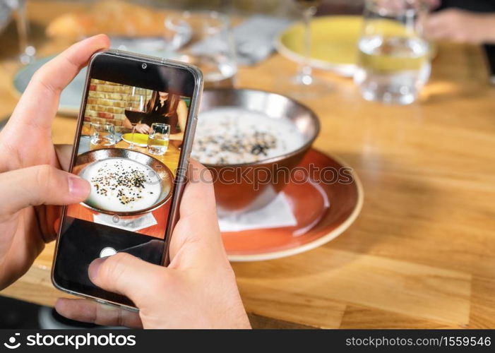 Man hand with smartphone photographing food at restaurant or cafe. High quality photo. Man hand with smartphone photographing food at restaurant or cafe