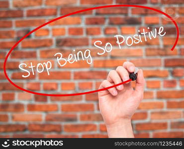 Man Hand writing Stop Being So Positive with black marker on visual screen. Isolated on bricks. Business, technology, internet concept. Stock Photo