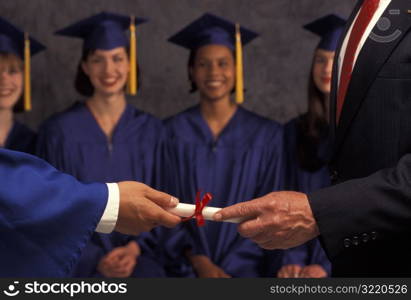 Man Handing Diploma To Graduate