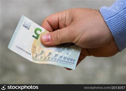 Man hands giving money. Holding EURO banknotes on a blurred background, EU currency. Man hands giving money. Holding EURO banknotes on a blurred background, EU currency