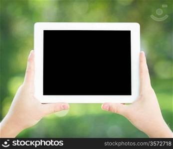 Man hands holding tablet PC against spring green background