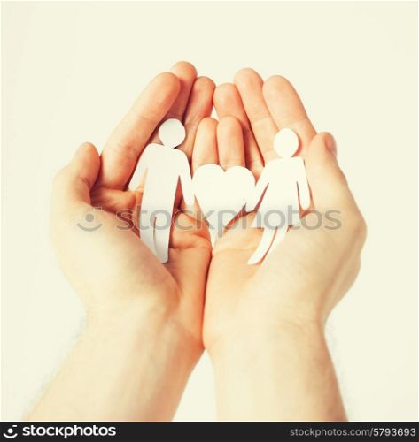 man hands showing two paper men with heart shape
