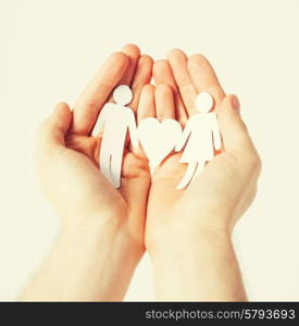 man hands showing two paper men with heart shape