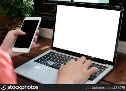 Man hands typing laptop computer and smart phone with blank screen for mock up template background, business technology and lifestyle background concept