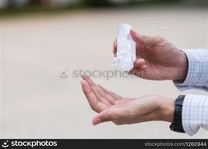 man hands using wash hand sanitizer gel dispenser, against Novel coronavirus or Corona Virus Disease (Covid-19) at public train station. Antiseptic, Hygiene and Healthcare concept