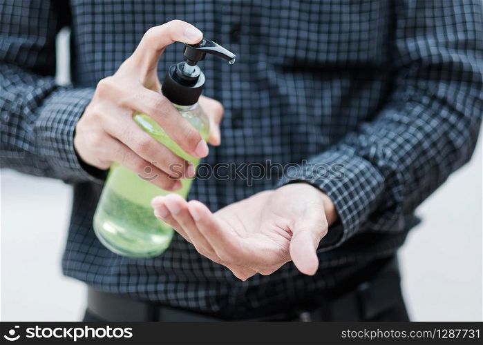 man hands using wash hand sanitizer gel dispenser, against Novel coronavirus or Corona Virus Disease (Covid-19) at public Indoor. Antiseptic, Hygiene and Healthcare concept