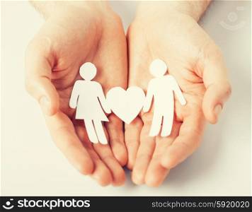 man hands with paper men. man hands showing two paper men with heart shape