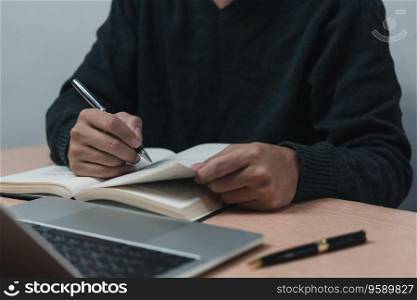 man hands with pen writing on notebook in the office.learning, education and work.writes goals, plans, make to do and wish list on desk.