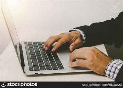 Man hands working on laptop keyboards, searching the Internet or shopping online or sending emails at their desks.