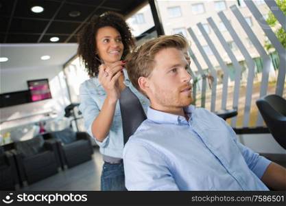 man having a haircut from a female hairdresser