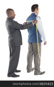 Man having back measured by tailor