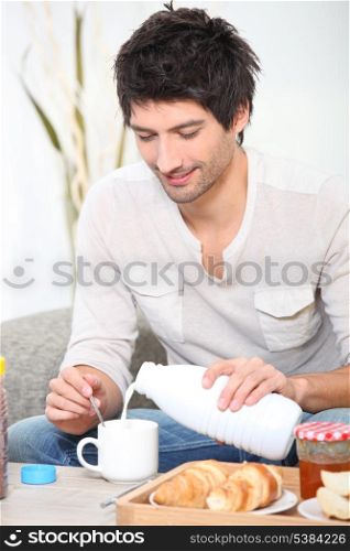Man having breakfast on the sofa