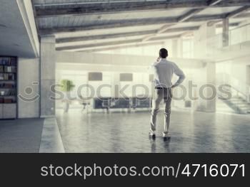 Man having business talk mixed media. Man boss having mobile phone conversation while standing in modern office
