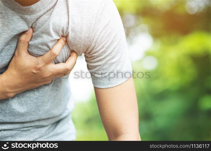 Man having chest pain - heart attack outdoors. or Heavy exercise causes the body to shocks heart disease