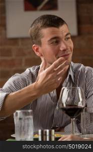 Man having fun at restaurant while drinking red wine and chatting with friends