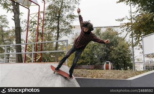 man having fun with skateboard outside city park