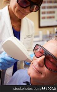 Man Having Laser Treatment At Beauty Clinic