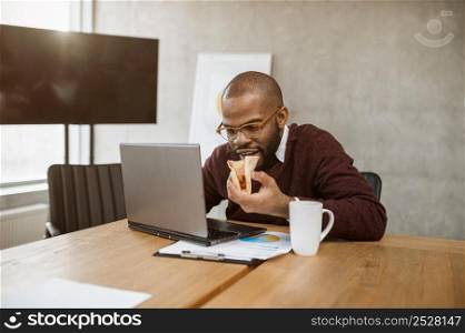 man having pizza during office meeting break