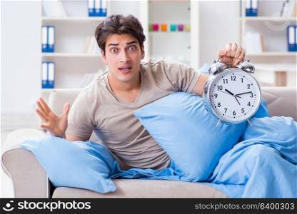 Man having trouble waking up with alarm clock