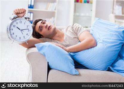 Man having trouble waking up with alarm clock