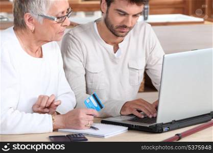 Man helping elderly family member shop on-line