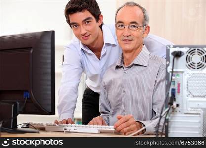 Man helping granddad with computer