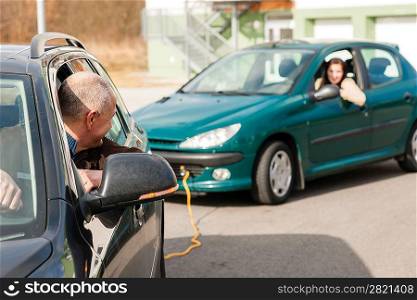 Man helping woman by pulling her car problem breakdown cable