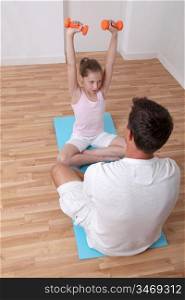 Man helping young girl with fitness exercises