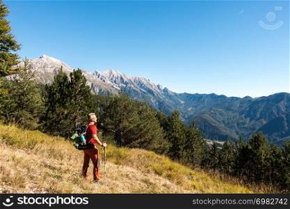 Man hiker is admiring the range mountains landscape.