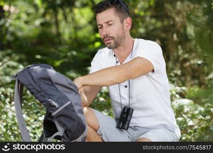 man hiker looking for something in his bag