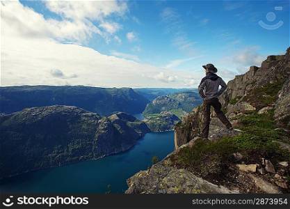 Man hiker looking over fjord panorama