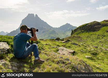 man hiker with camera and taking picture of beautiful mountain